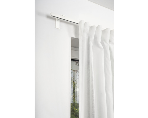 Gardine mit Gardinenschiene an der Wand vor einem Fenster