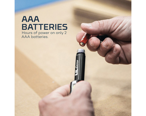 Eine Person legt eine AAA-Batterie in eine Lampe ein.