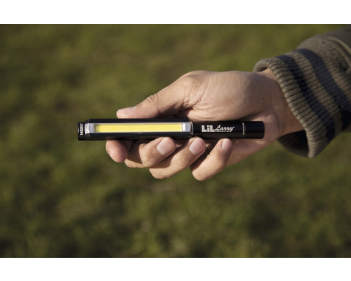 Eine Hand hält eine schwarze Lil Larry Stablampe.