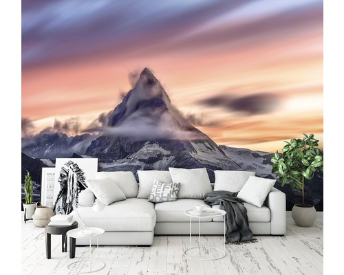 Wohnzimmer mit Bergpanorama-Fototapete hinter einer Couch