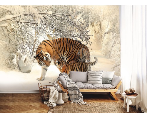 Fototapete mit Tigerfamilie in Winterlandschaft hinter einem Sofa