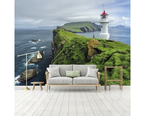 Wandbild mit Leuchtturm, Klippe und Meer in einem hellen Raum