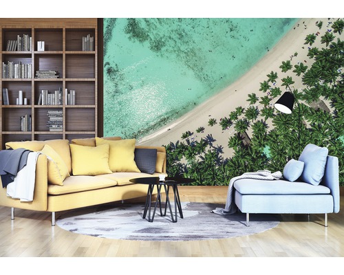 Wohnzimmer mit Bücherregal, gelbem Sofa, Couchtisch und Fototapete mit Strandmotiv