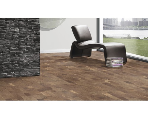 Modernes Wohnzimmer mit dunklem Laminatboden, Steinwand und Sessel