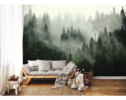 Wohnraum mit Fototapete eines nebligen Waldes, Sofa und Dekorationen