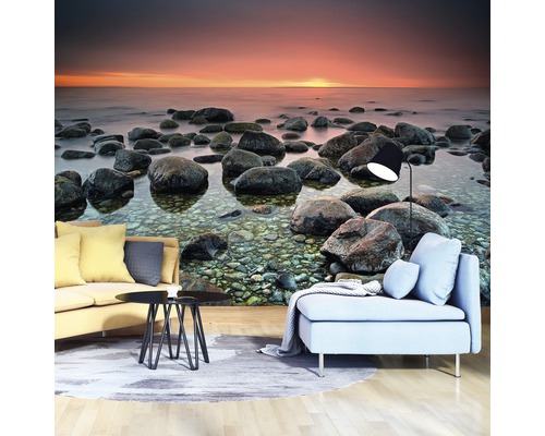 Wohnzimmer mit Fototapete mit Steinstrandmotiv bei Sonnenuntergang