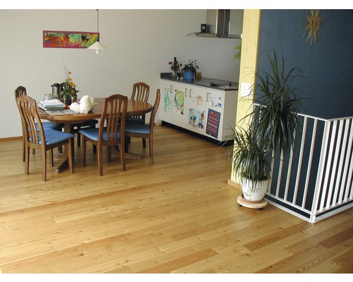 Esszimmer mit Holzboden, Esstisch und Stühlen.