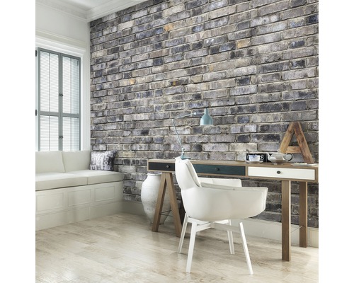 Wohnraum mit gemauerter Wand, Schreibtisch und Sitzgelegenheit