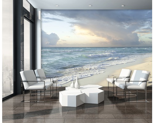 Wohnraum mit Fototapete, die einen Strand und das Meer zeigt, ausgestattet mit Sesseln und einem Tisch