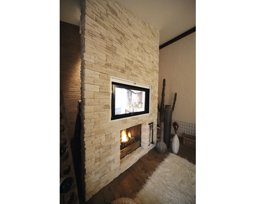 Wohnzimmer mit Kamin und Fernseher in Steinwand