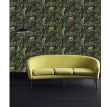 Zimmer mit Dschungeltapete, darauf Affen und Papageien, sowie einem Sofa und einer Stehlampe