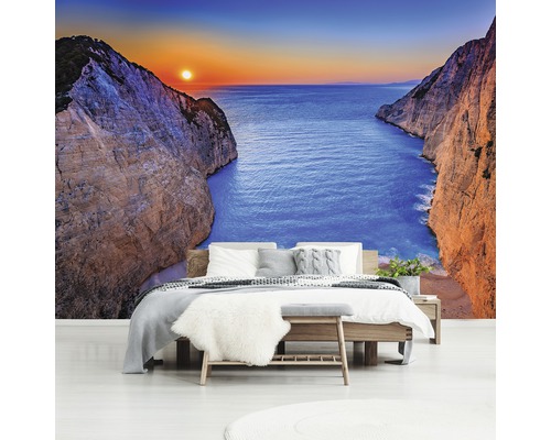 Wandbild im Schlafzimmer mit einem Blick auf Meer zwischen Klippen bei Sonnenuntergang.
