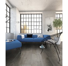 Heller Raum mit Sofa, Sessel und großem Fenster mit Sprossen