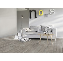 Wohnzimmer mit grauer Couch, Holztisch und Laminatboden