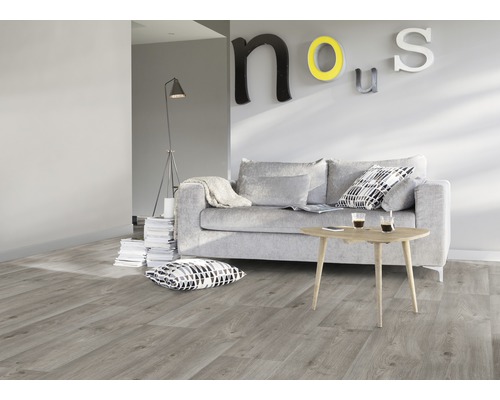 Wohnzimmer mit grauer Couch, Holztisch und Laminatboden