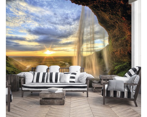 Wohnzimmer mit Fototapete, die einen Wasserfall und eine Landschaft bei Sonnenuntergang zeigt.