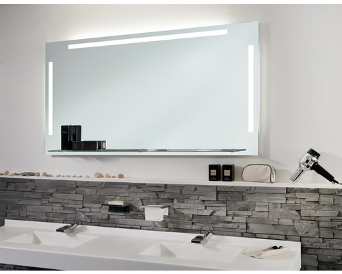 Badezimmer mit beleuchtetem Spiegel und Doppelwaschbecken.