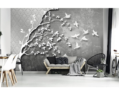 Wohnzimmer mit einer Fototapete, die einen Baum und fliegende Vögel zeigt.