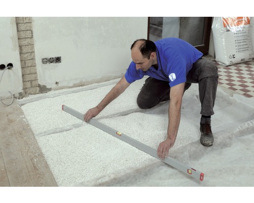 Handwerker ebnet Bodenausgleichsmasse mit einer Wasserwaage in einem Raum.