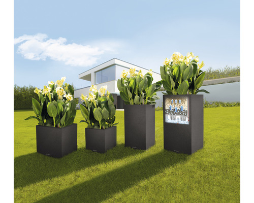 Vier quadratische Pflanzkübel aus Kunststoff mit Pflanzen im Garten