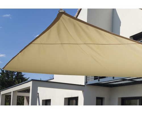 Dreieckiges Sonnensegel aus Stoff vor einem Gebäude.