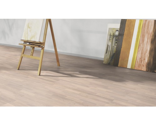 Raumansicht mit hellem Laminatboden, Staffelei und Gemälden