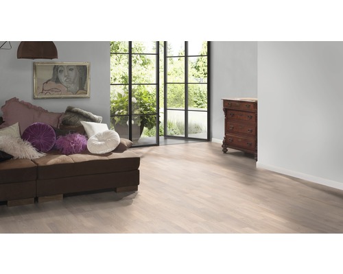 Wohnzimmer mit Couch, Kommode und hellem Laminatboden