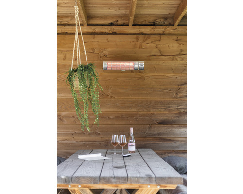Überdachte Terrasse mit Heizstrahler, Tisch, Weinflasche und Gläsern