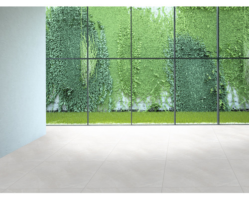 Innenraum mit Fliesenboden und Blick durch ein großes Fenster auf eine grüne Pflanzenwand.