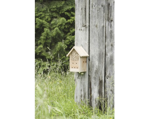 Insektenhotel aus Holz an einer Holzwand befestigt