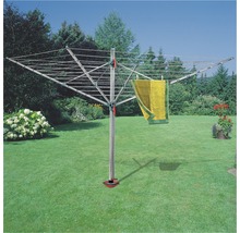 Drehflügelwäscheständer im Garten mit einem aufgehängten Handtuch.