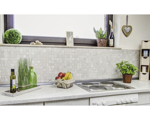 Küchenszene mit Mosaikfliesen-Rückwand und Dekorationen auf der Arbeitsplatte.