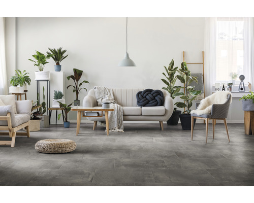 Heller Wohnraum mit Sofa, Stühlen, Pflanzen und Bodenfliesen in Steinoptik
