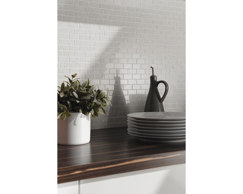 Szene mit Mosaikfliesen im Backsteindesign, Arbeitsplatte, Geschirr und Dekoration