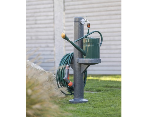 Gartenszene mit Wasserzapfsäule, Gießkanne und Gartenschlauch.