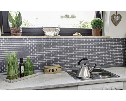 Küchenszene mit Mosaikfliesen, Kochfeld, Teekessel und Dekoration