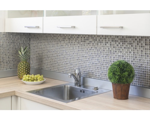 Küchenspüle mit Armatur, Mosaikfliesen, Ananas, Trauben und Topfpflanze auf einer Arbeitsplatte