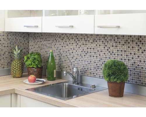 Küchenspüle mit Armatur, Mosaikfliesen, Küchenschränken und Dekorationen wie einer Ananas und einem Topf Basilikum