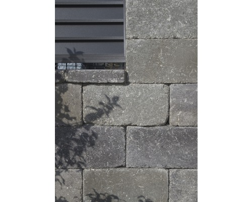 Mauer aus Betonsteinen mit Fenstergitter