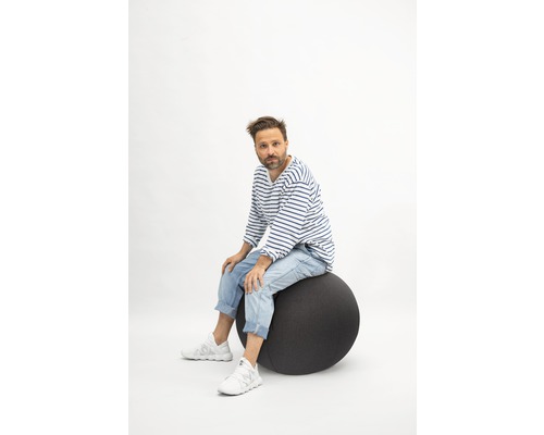 Mann sitzt auf einem Gymnastikball
