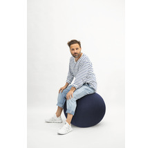 Mann sitzt auf einem Gymnastikball.