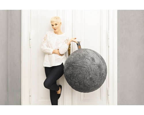 Dekorativer Sitzsack in Kugelform neben einer Frau an einer Tür