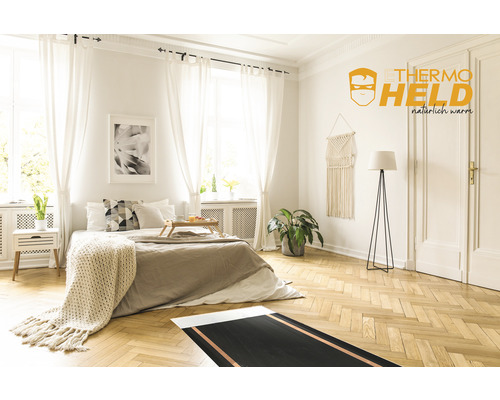 Schlafzimmer mit Teppichheizung auf Holzboden und Thermoheld Logo an der Wand