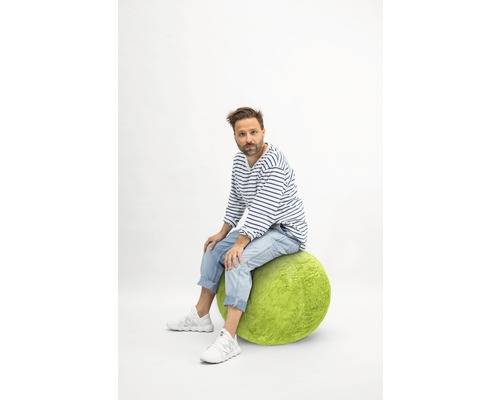 Mann sitzt auf einem grünen Sitzball