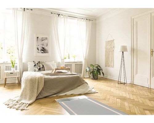 Helles Schlafzimmer mit Bett, Nachttisch, Stehlampe, Fenster und Teppich