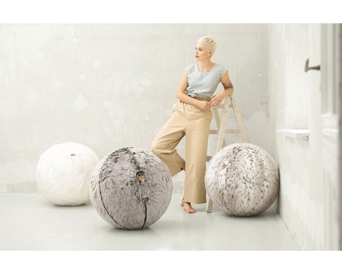 Szene mit einer Frau, die an einer Leiter lehnt, und drei runden Sitzsäcken in Weiß und Grau