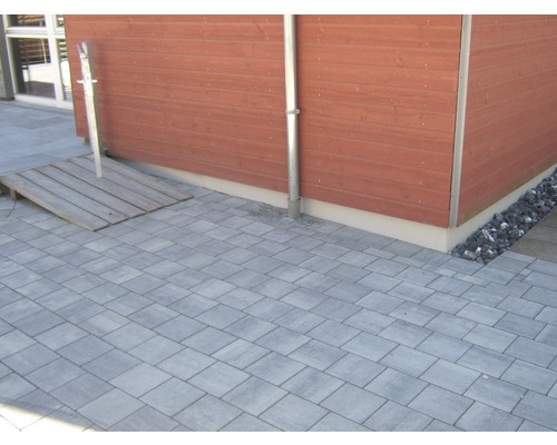 Gepflasterter Hof mit Holzrampe und Holzwand