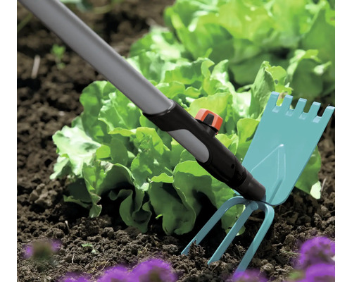 Gartengerät zur Bodenbearbeitung im Beet mit Salatpflanzen
