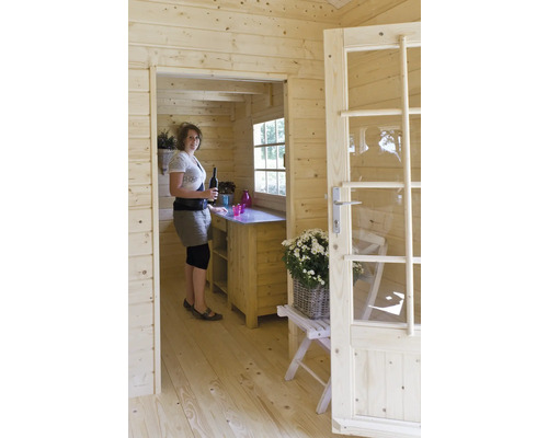 Innenansicht eines Holzhauses mit Frau, Theke und teilweise geöffneter Tür