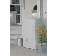 Wassertank mit Wasserhahn, Gießkanne und Bepflanzung vor einem Haus